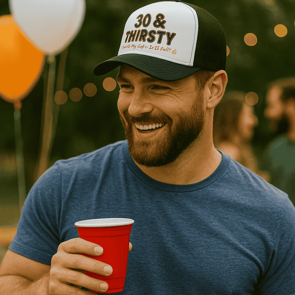Man wearing a cap with '30 & THIRSTY' text, holding a red cup, with balloons and people in the background.